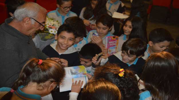 Yazar Erdal Çakıcıoğlu çocuk kitaplarını imzalarken